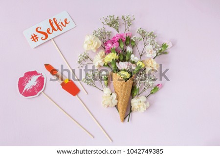 festive background: on a pink wafer table and in it a bouquet of flowers and pictures for a hen party