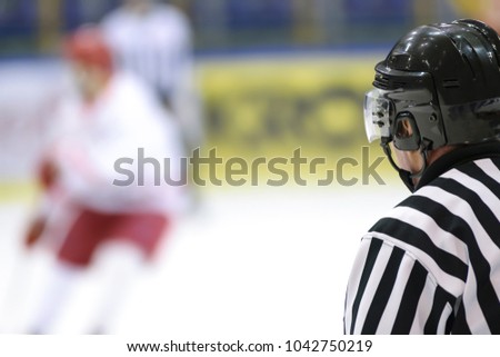Hockey sport background - rear view of the referee against the blurry hockey game.