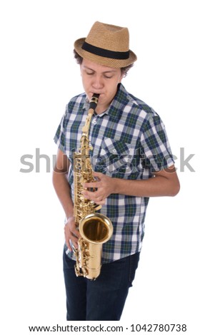 A young musician blowing in the saxophone looking down, wearing a hat and plaid shirt, isolated on a white background.