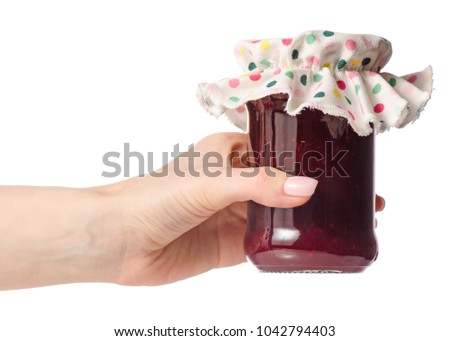 Raspberry jam in a jar in hand on white background isolation