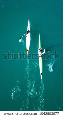 Aerial photo of colourful sport canoes in competition as shot from above in turquoise clear waters
