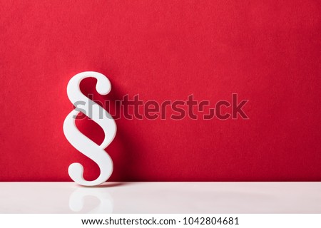 Close-up Of A Paragraph Symbol Leaning On Red Wall