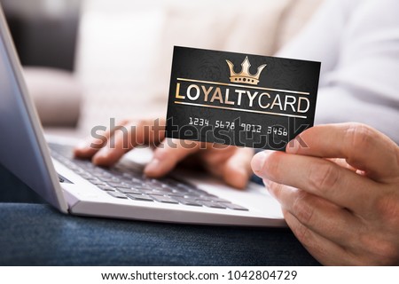 Close-up Of A Person's Hand With Loyalty Card Using Laptop Royalty-Free Stock Photo #1042804729