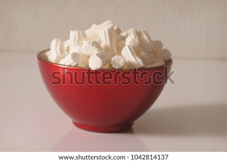 A red plate wit marshmallows on a white background. Close up. Christmas photo.  