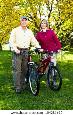 Happy Senior couple cycling in the park.