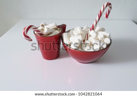 Christmas background, greeting card with a Cup of coffee or hot chocolate with marshmallows, a red plate and candy canes. Holiday photo. The mood of the expectations of celebration