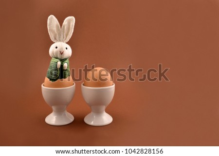 Easter bunny and egg stock images. Easter bunny and egg on a brown background. Easter bunny in an egg. Spring decoration images. Easter concept