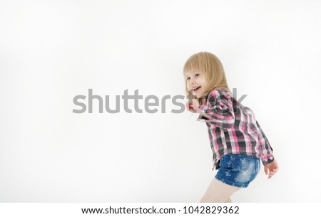 Copy space.Portrait of a cheerful and positive little blond girl dressed in a plaid shirt and denim skirt looking with a laugh in the direction of the screen isolated on a white background. LIFESTYLE
