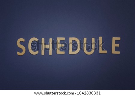 Schedule written with wooden letters on a blue background to mean a business concept
