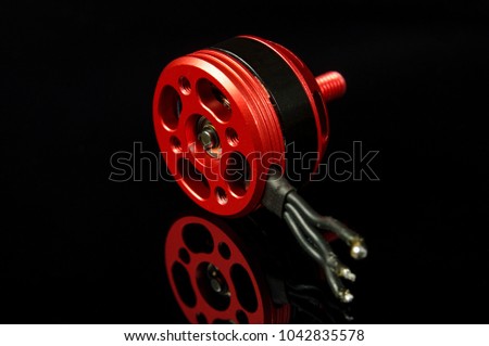 Small brushless motor for racing drones on the dark background Royalty-Free Stock Photo #1042835578
