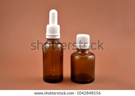 Two brown vials stock images. Empty cosmetic bottle. Vials on a brown background. Brown glass containers. Brown chemical glass