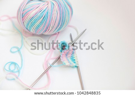 Knitting on knitting needles, a tangle of threads and knitting needles
