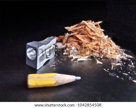 Isolated pencil sharpener (with pencil shavings) on the black background