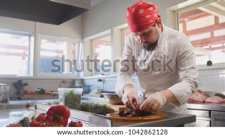 Chef serves the salad by placing the ingredients on a plate
