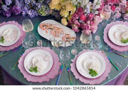 Festive table decor. Luxury wedding, party, birthday. View from above. Different seafood. White wine, prawns, fish. multicolored, Pink Lavender, Arcadia, Ultra Violet. flowers, carnations, roses.