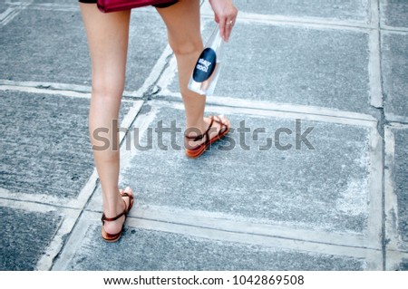 A woman is holding a platic bottle with water outdoor
