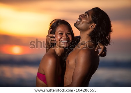 Young multi-ethnic couple on romantic beach at sunset in the tropics