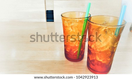 ice cubes in two orange glasses