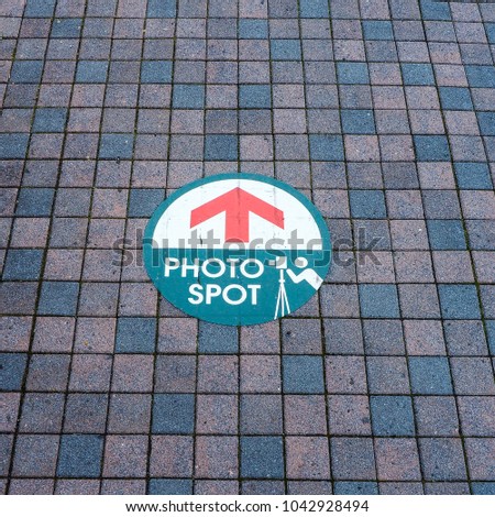 Look down at Japan footpath titles - Various color small rectangle block orderly align. With Photo Spot location sign.