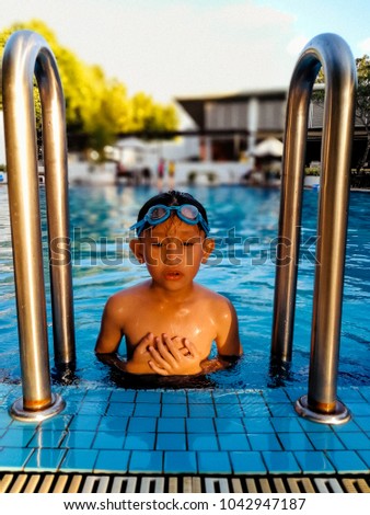 Asian boy swims in a pool.