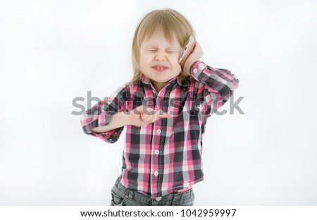 Portrait of an emotional and energetic little girl with blond hair and a checkered shirt talking with mom on the smartphone with closed eyes from indignation isolated on white background