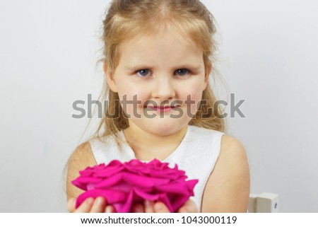 Portrait of a cute girl with a pink rose