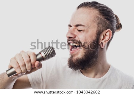 The entertainer. Young  talking man holding microphone, Isolated on white background.