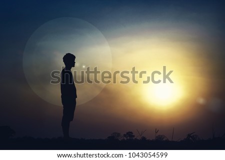 Silhouette of a man standing outdoors in light. Royalty-Free Stock Photo #1043054599