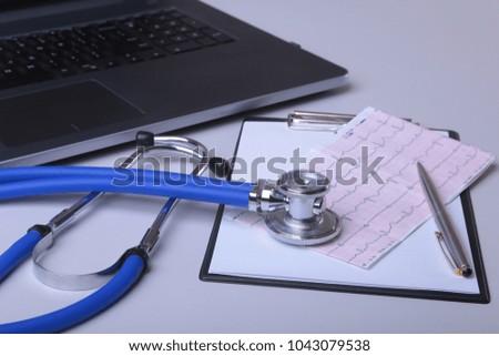 Workplace of doctor with laptop, stethoscope, RX prescription and notebook on white table. top view. Copy space.
