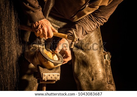 blacksmith working with a horse Royalty-Free Stock Photo #1043083687