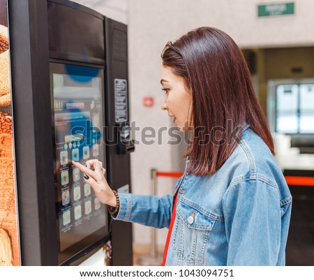 woman buying coffee from automatic vending machine Royalty-Free Stock Photo #1043094751