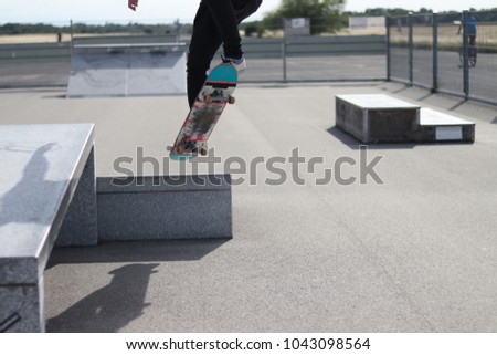 Young skater doing triks on a sunny day no face.Black Jeans black Tshirt