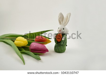 Easter Bunny with tulips stock images. Easter decoration on a white background. Spring decoration images. Bouquet of colorful tulips