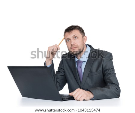 Bearded man in suit thinks sitting in front of laptop, isolated on white background.