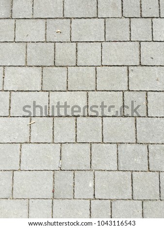 Detail of a textured dirty stone tiled sidewalk