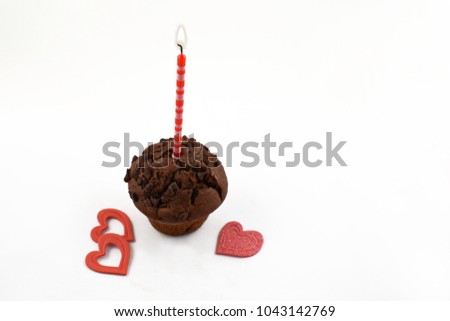 Romatic muffin with candle stock images. Chocolate muffin with hearts on a white background. Sweet party pastry. Valentines Day concept