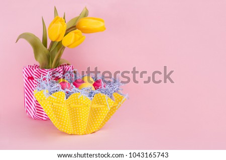 Easter sweet vanilla pink background with painted eggs, tulips bouquet, and copy space.
