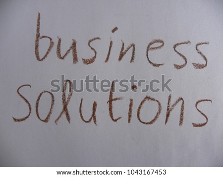 Text business solutions hand written by brown oil pastel on white color paper