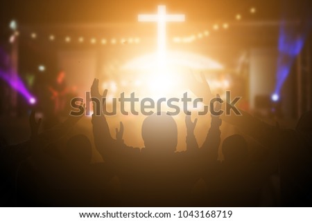 Christians raising their hands in praise and worship at a night music concert. Eucharist Therapy Bless God Helping Repent Catholic Easter Lent Mind Pray. Christian concept background. Royalty-Free Stock Photo #1043168719
