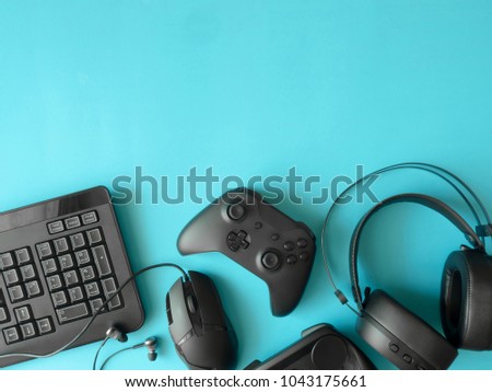 gamer workspace concept, top view a gaming gear, mouse, keyboard, joystick, headset on blue table background with copyspace.