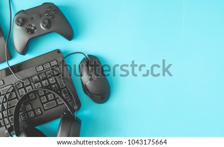 gamer workspace concept, top view a gaming gear, mouse, keyboard, joystick, headset on blue table background with copyspace.