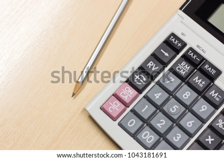 pencil and calculator on wood table