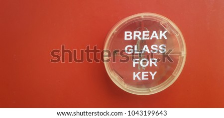 Emergency break glass for key on red background with copy space for your text.