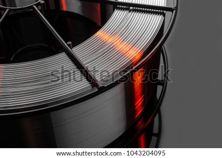 welding wire, stainless steel, on a black background Royalty-Free Stock Photo #1043204095