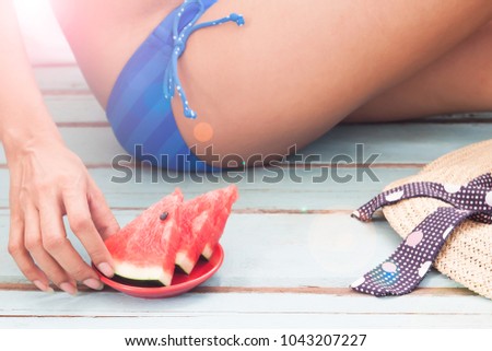 Woman in blue color bikini eating watermelon, Summer and Beauty concept 