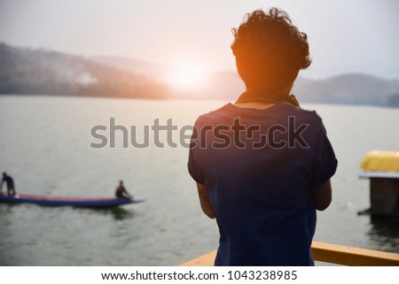 Man holding camera on hand against river on background