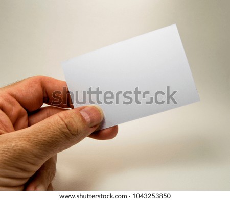 white empty card  with a man hand, for free text, on a gray background