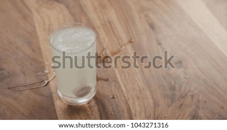 effervescent tablet in glass of water on wood table