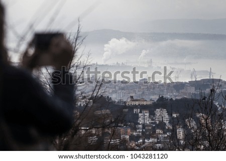 Woman taking picture from a hill