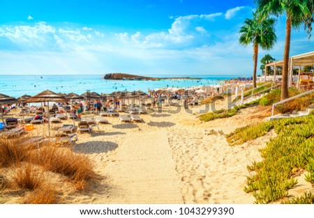 View of turquoise water Nissi beach in Aiya Napa, Cyprus. Ayia Napa coastline. Beautiful sand beach in Aiya Napa, Cyprus. Famous tourist beach in Cyprus Royalty-Free Stock Photo #1043299390